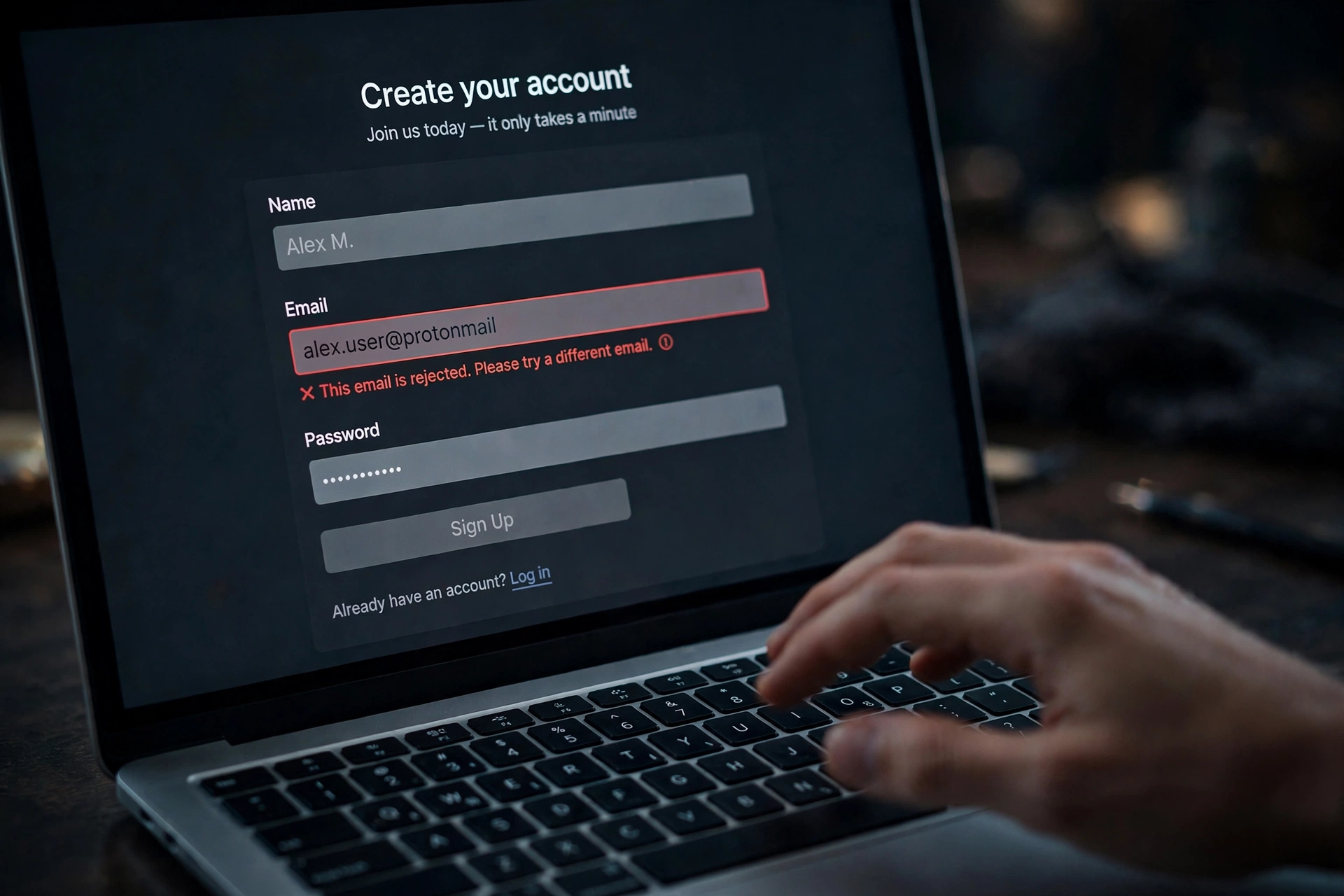 A laptop signup form rejecting an email address, illustrating disposable domains blocked at signup